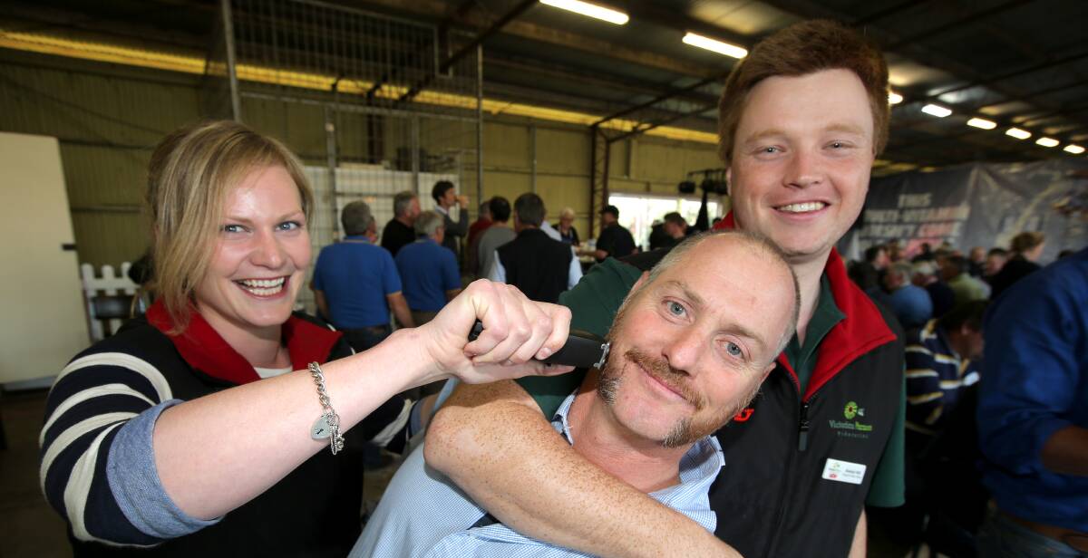 Mo-off: United Dairyfarmers of Victoria staff Alison Lee and Alastair Hilli threaten UDV president Adam Jenkins with the clippers prior to his moustache shave.