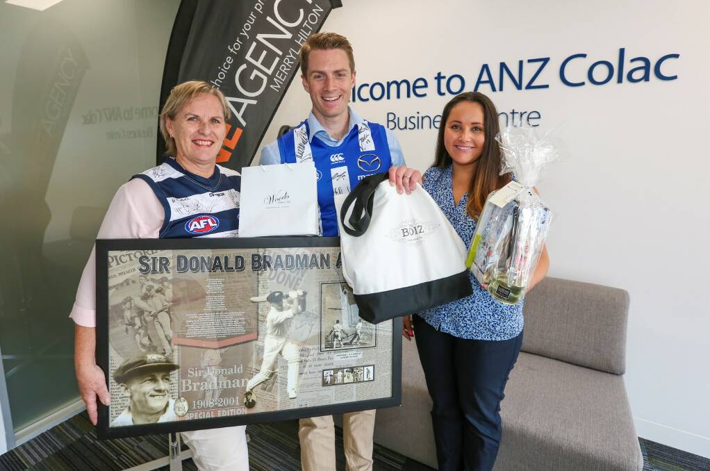 Doing their bit: One Agency's Merryl Hilton, left, with ANZ's Dale Camm and Alana Pittard show some of the items to be auctioned at the fire relief auction on April 21. Picture: Tammy Brown 