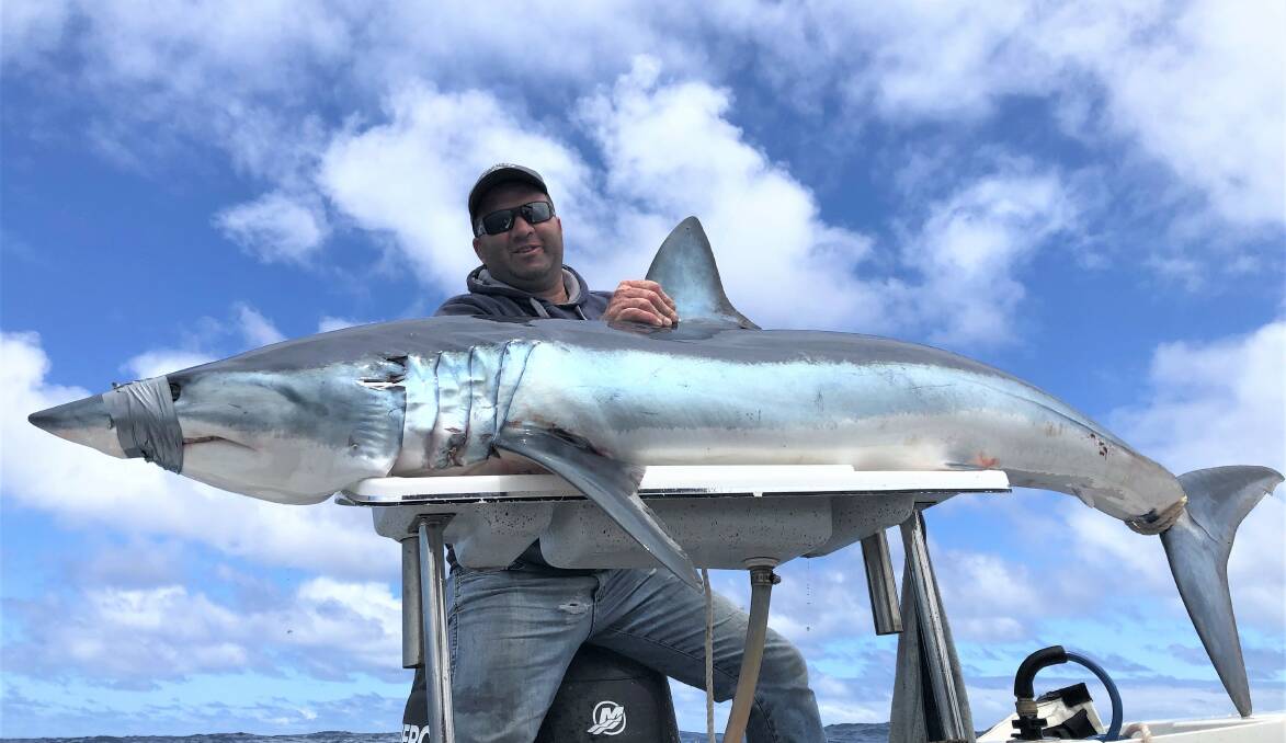Grant Bellman with the 80.8 kilogram mako shark he caught during the Shipwreck Coast Fishing Classic.