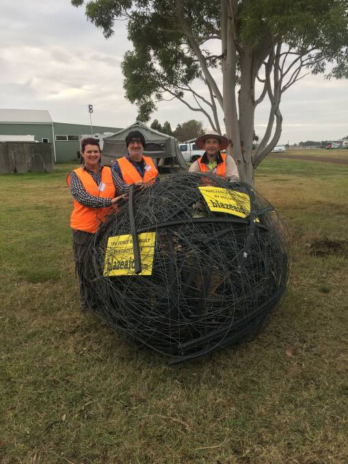 Collected: Blaze Aid volunteers Jenny Zautsen, Rudy Van Der Korput and Bill Faull with a big ball of fencing wire collected from properties burnt in the St Patrick's Day Gazette fire. Blaze Aid has suggested the ball of wire could become an art installation.