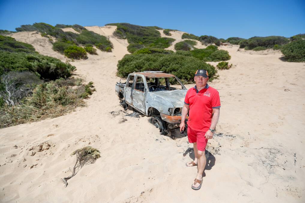 DEGRADED: Warrnambool Cr Peter Hulin stands in front of a burnt out car behind Spookys beach. He says fixing up the area is a top priority. Picture: Morgan Hancock 