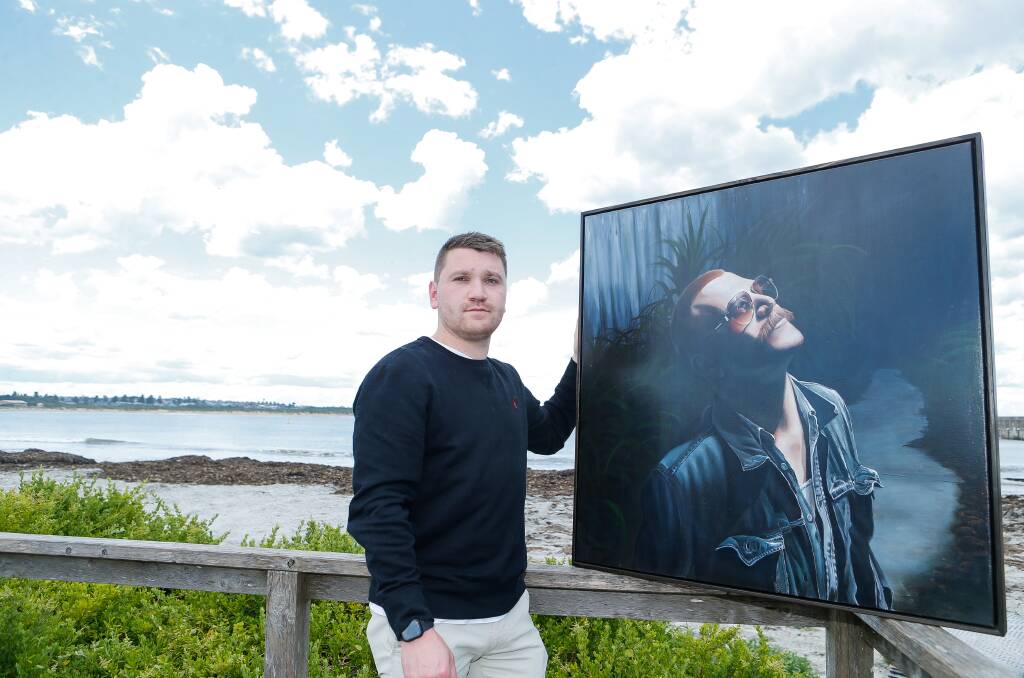 Tate Heath with a painting of his twin brother Guy. 