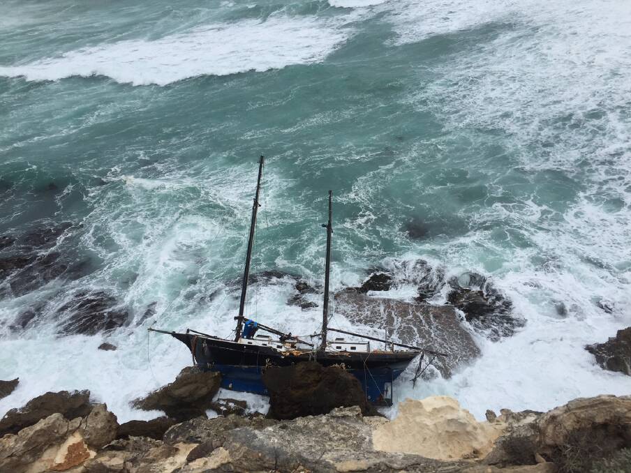 PRECARIOUS POSITION: The yacht washed up on rocks at Lake Gillear a month ago and two attempts to salvage it have failed. It has undergone substantial damage. Picture: Supplied
