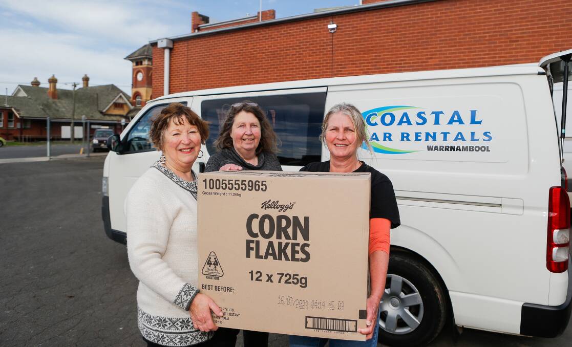 HELPING HAND: Julie Pomeroy from Terang's Anglican Church and Andrea Balcombe from the Terang Community Op Shop hand over $2000 of groceries to Anglicare's Louise Serra. Picture: Anthony Brady