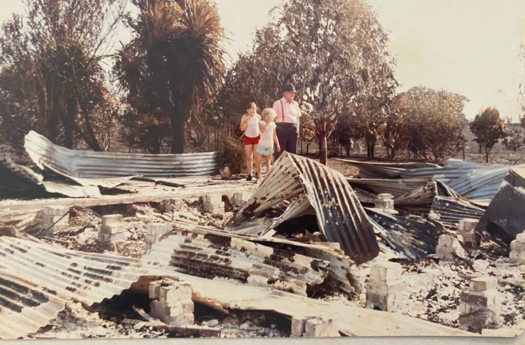 DESTROYED: Kristy and her sister Rebecca check out what remains of their house with their grandfather Ab Plozza after the Ash Wednesday bushfires.