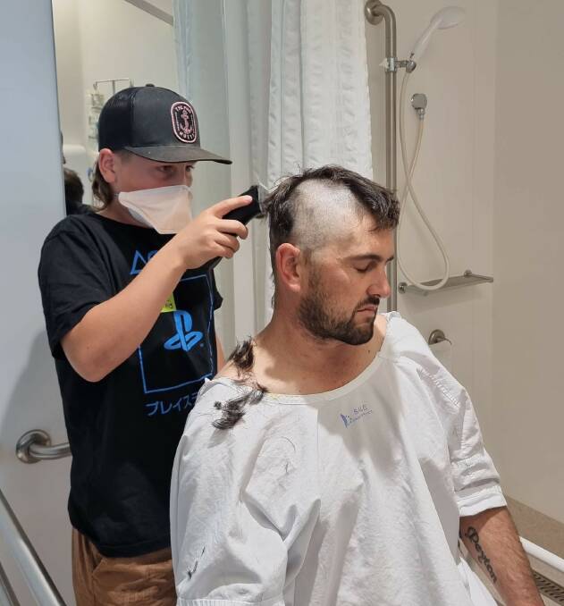 HELPING HAND: Gus helps his dad Damian Jones shave his head at the Andrew Love Cancer Centre in Geelong.