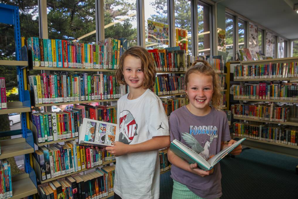ALL SMILES: Archie, 10, and Harper Campbell, 8, check out a book at the Warrnambool library, which is abolishing late fees. Picture: Morgan Hancock