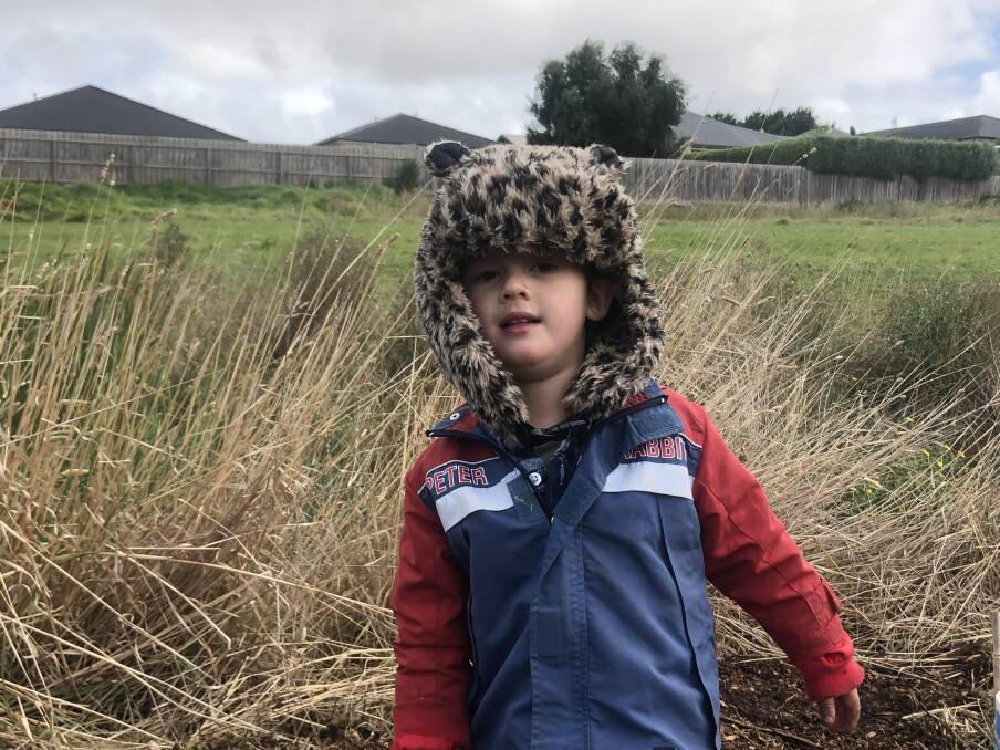 HELPING OUT: Oliver Dart, 3, braved Warrnambool's cool conditions and got his hands dirty to plant trees along Russells Creek on Sunday.