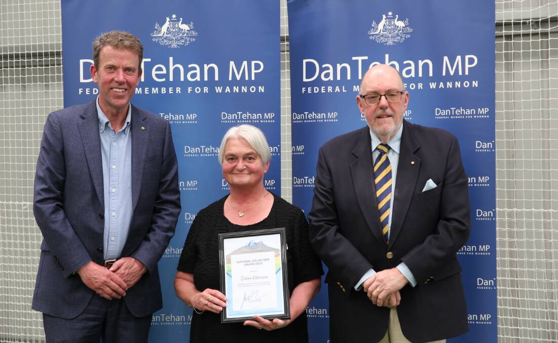 Debra Robinson, centre, is presented with her award by Dan Tehan and Mick Murphy.