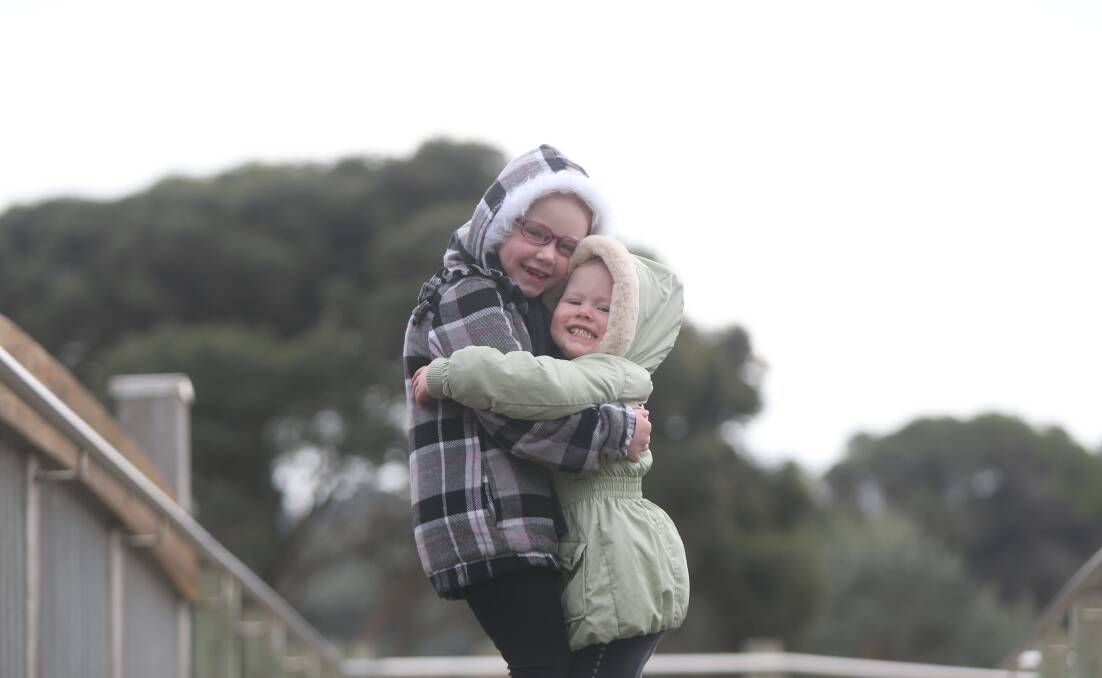 RUGGED UP: Gabriela Rhyne, 5, and sister Zoe, 3, brave the cold at Lake Pertobe. Picture: Mark Witte 