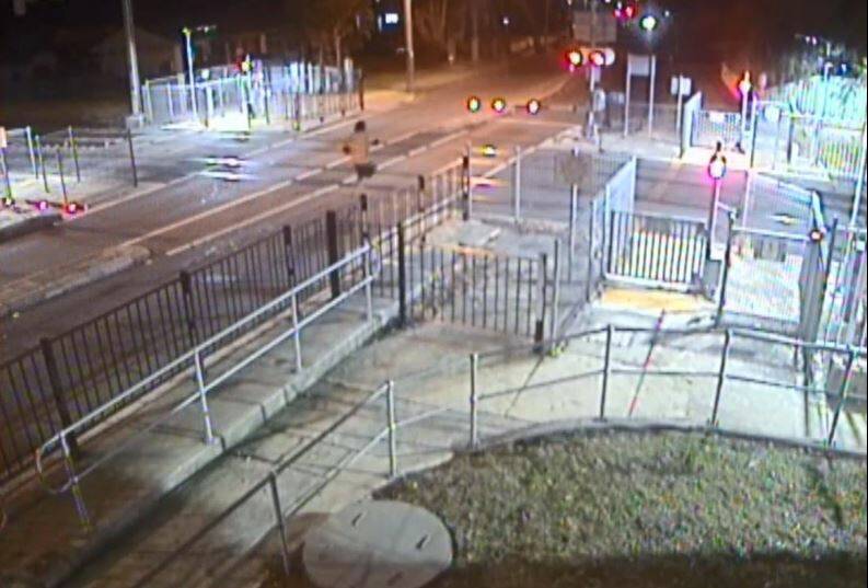 Crazy: A man races through the level crossing, right in the path of not one, but two trains. Picture: Transport for NSW