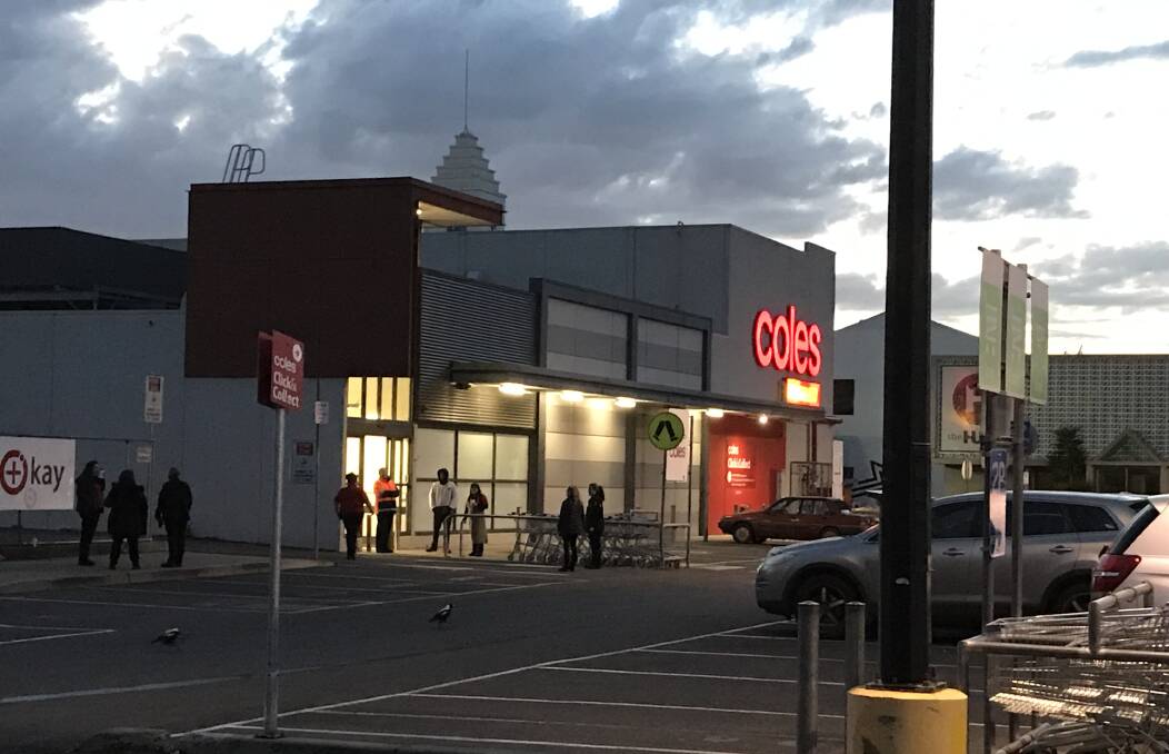Cool start: Staff wait outside the Coles supermarket in Lava Street, Warrnambool, at 7am for the all clear to return to work. A faulty fire alarm caused the store to be closed.