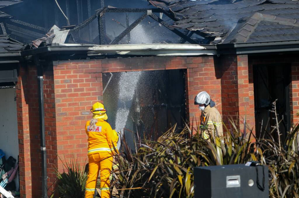 Charges: Firefighters douse a house which suffered about $350,000 damage in a fire on Wednesday. Picture: Anthony Brady