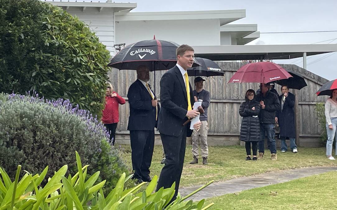 Ray White Real Estate auctioneer Fergus Torpy was made to work hard in persistent rain to achieve the sale of No. 4 Howard Street in Warrnambool on Saturday morning. The property sold for $765,000 after a surprise late bid.