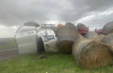 The driver and a child passenger suffered minor injuries in the hay truck rollover late Saturday afternoon. Pictures supplied.