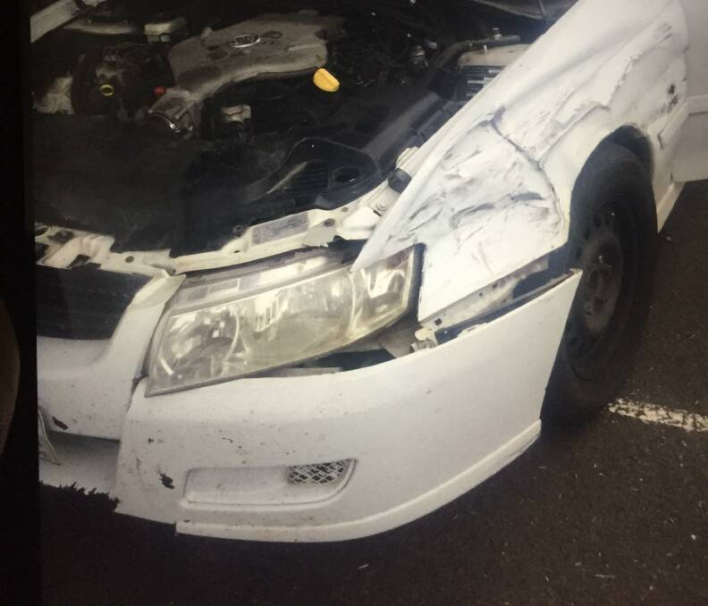 The damaged white Holden Commodore sedan.