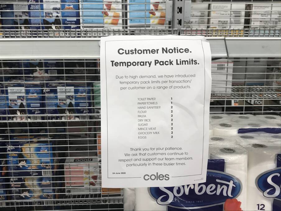 Panic: The notice of buyer restrictions at a Coles supermarket on Thursday morning. The shelves were only half full of toilet paper.