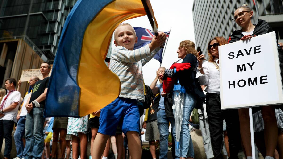 Protesters hold placards and flags during a rally against the war in Ukraine in Sydney on Sunday. Photo: AAP Image/Brendon Thorne