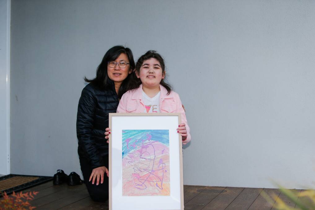 BRIGHT LIGHT: Naomi Philpot with part of the artwork published by The Lancet medical journal. She's with mum Anna. Picture: Anthony Brady