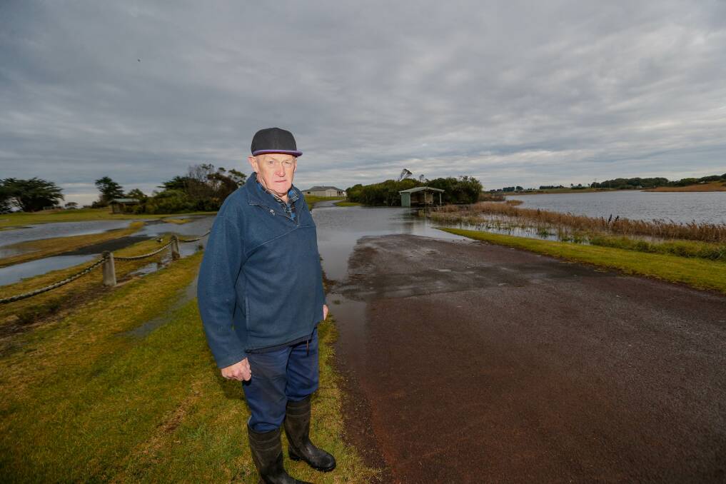 UNDER WATER: Narrawong farmer Owen Roberts at a submerged section of road leading to the a caravan park site. 