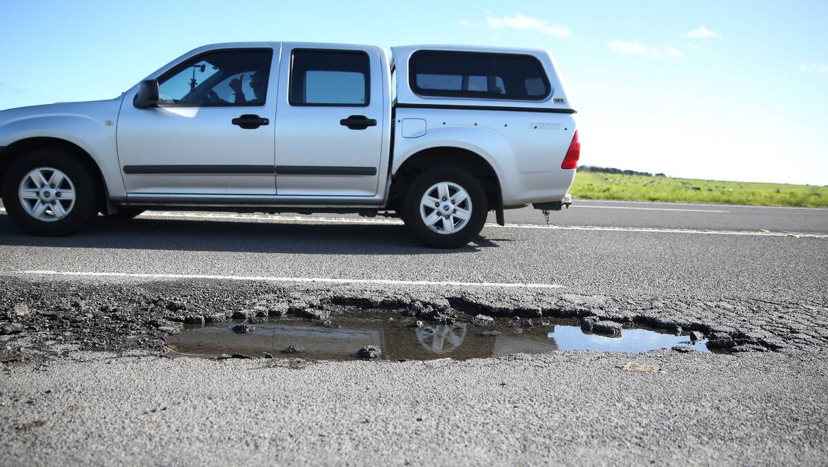 A car drives past a pothole on the Princes Highway between Dennington and Illowa. Picture: Mark Witte