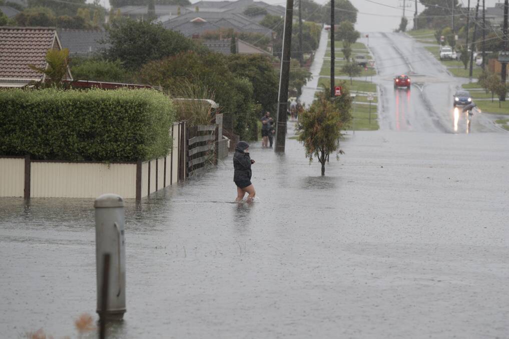 A pedestrian stands on a flooded Warrnambool street. Picture: Morgan Hancock