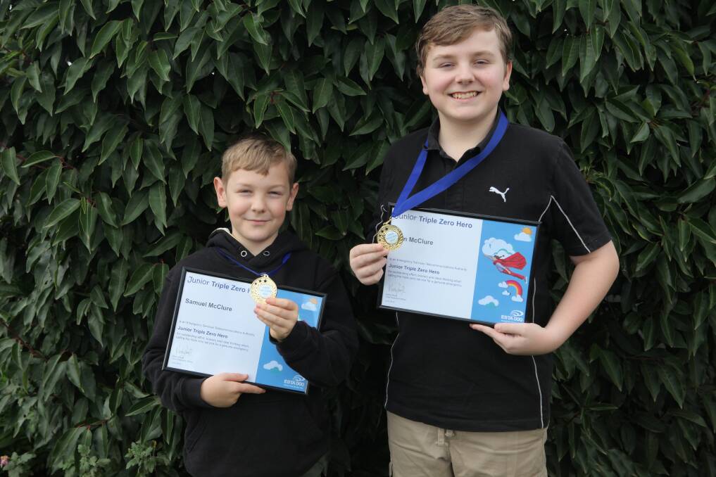 Hamilton brothers Samuel and Phin McClure, 9 and now 13, with their Triple Zero Hero awards recognising their bravery calling an ambulance when their mum Richelle displayed stroke-like symptoms. Picture: Kyra Gillespie