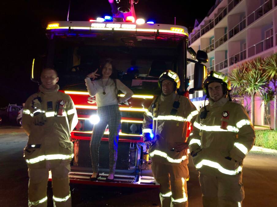 Party trick: Taliah, 13, gets a photo with firefighters after the DJ at her party set the smoke alarms off at Lady Bay Resort.