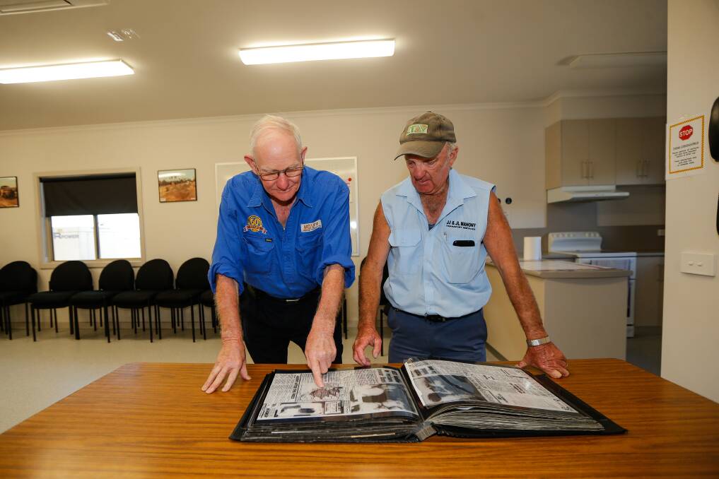 A dark day: Naringal CFA members Kelvin Boyle and John Mahony flick through old newspaper clippings and photos from Ash Wednesday. Picture: Anthony Brady