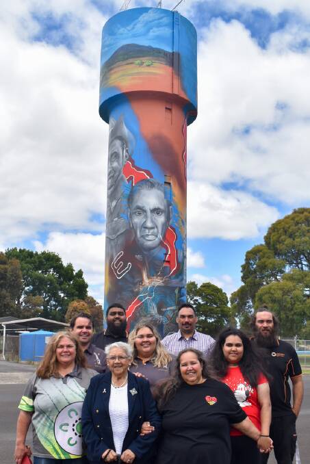 The Lovett family standing proudly with the mural depicting their anscestors who fought in the First and Second World Wars. There were 13 members of the Lovett family that served in both world wars.