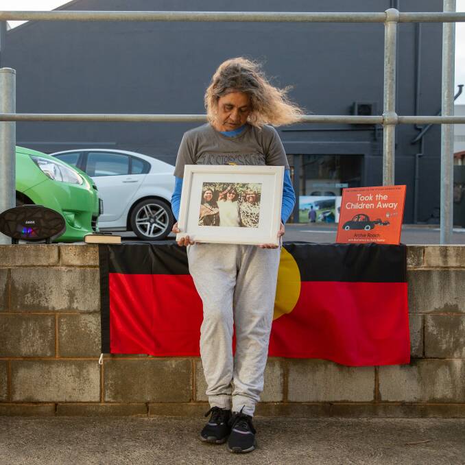 Stolen generation child Tracy Roach holds a photo of her and her mother during a protest of the continued removal of Aboriginal children from their homes in Warrnambool last year. Picture: Chris Doheny