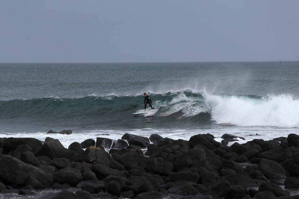 A file photo of a surfer catching a wave at The Passage in Port Fairy.