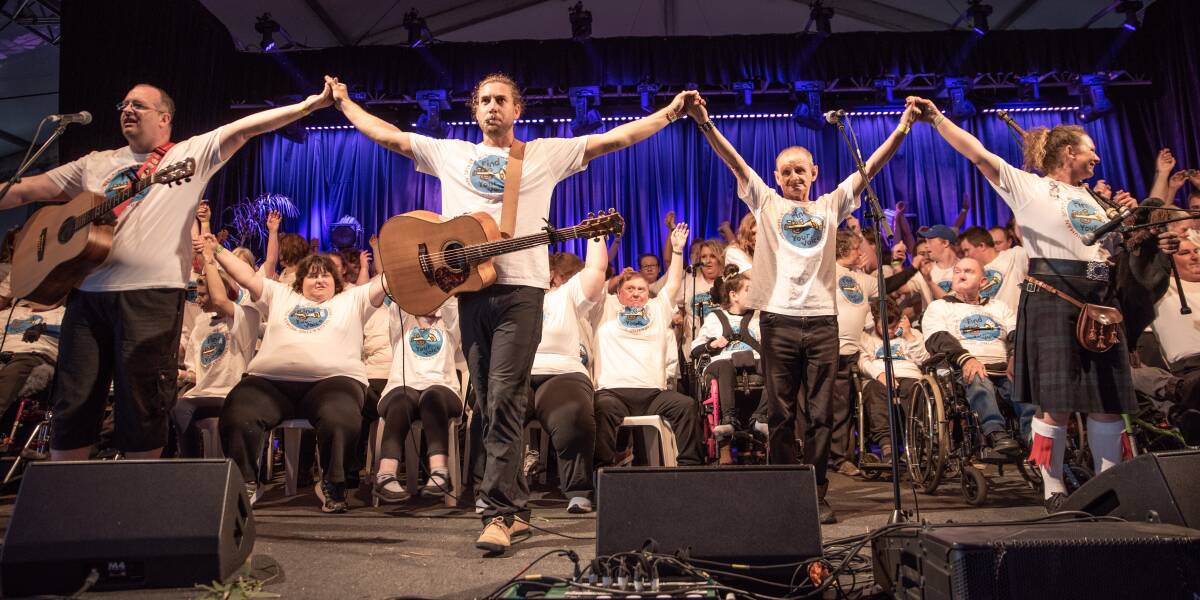 Headliners: Tom Richardson and the Find Your Voice choir raise their hands in the air after their show at the 2019 Port Fairy Folk Festival. Picture: Rodney Harris