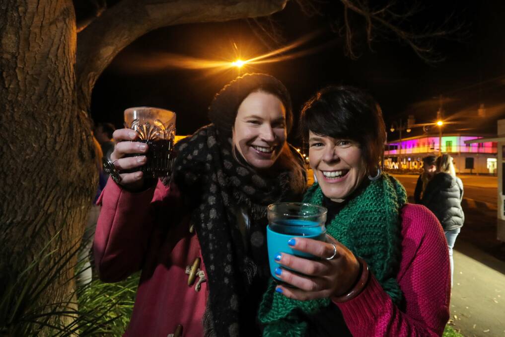 Rug Up: Port Fairy's Holly and Amanda Sheehan rug up and enjoy a glass of mulled wine at the 2018 Winter Weekend's opening. Picture: Rob Gunstone