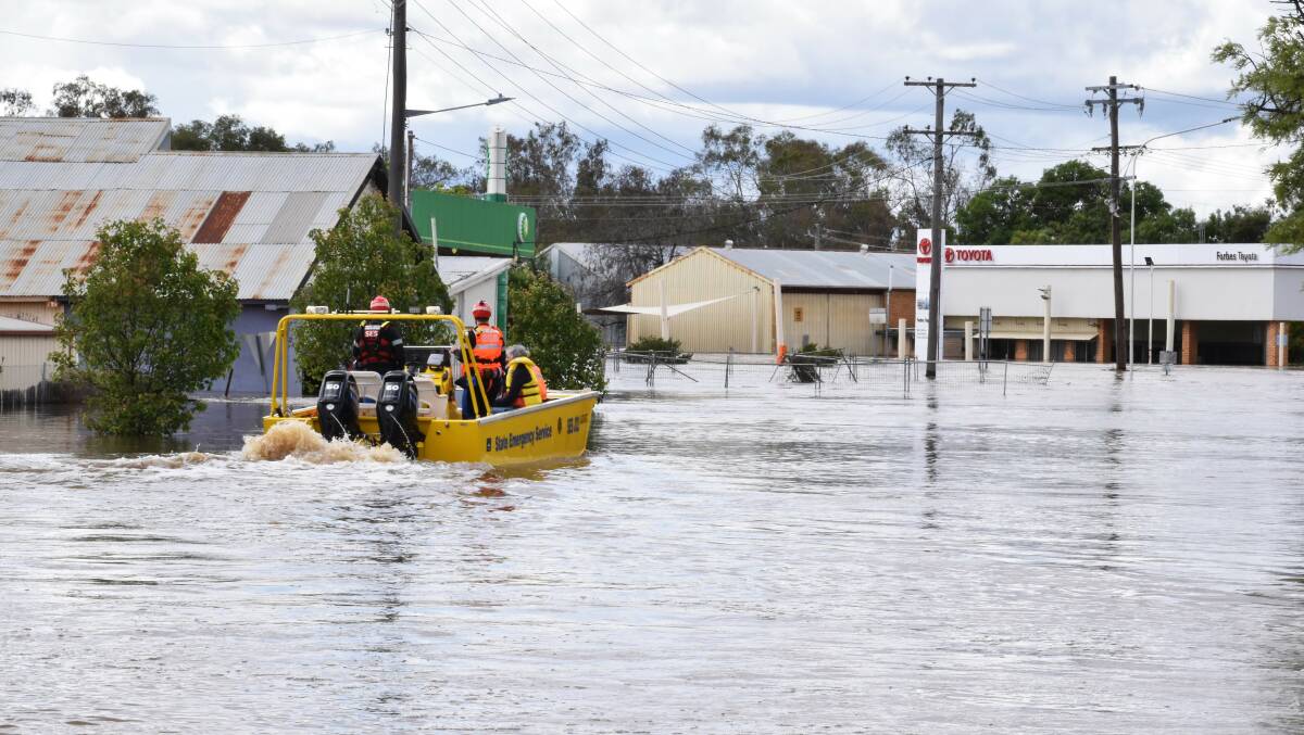 A boat ferries residents through floodwater in Forbes, Central West NSW. Picture by AAP Image/Murray McCloskey 