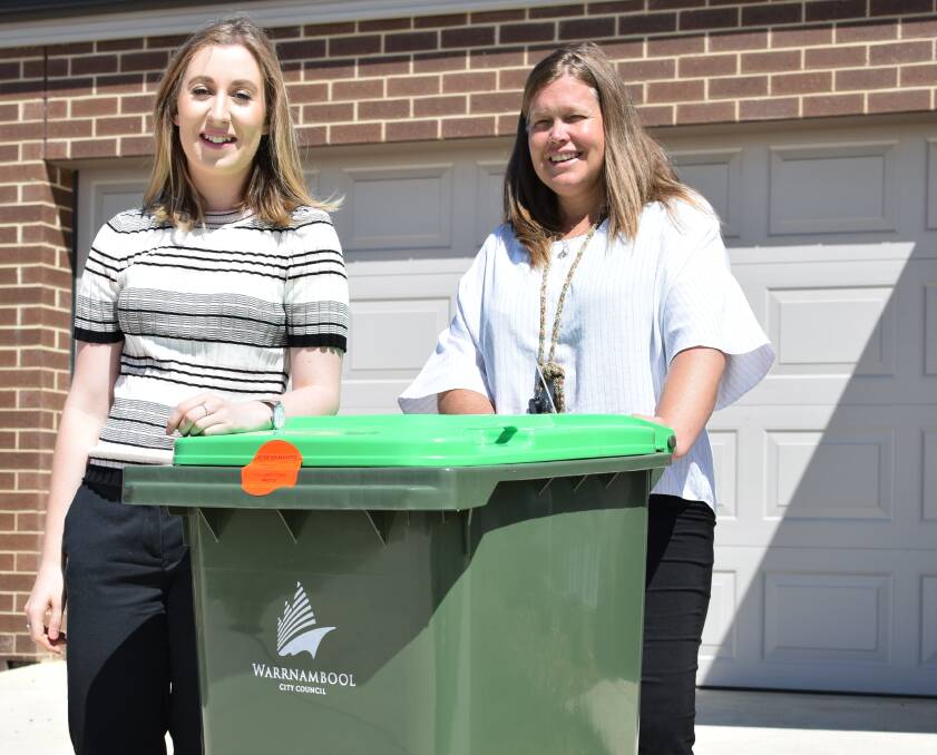 GOING GREEN: North Warrnambool resident Stephanie Bant and Warrnambool City Council waste management officer Kate McInnes with one of the green bins when the FOGO trial was first rolled out.