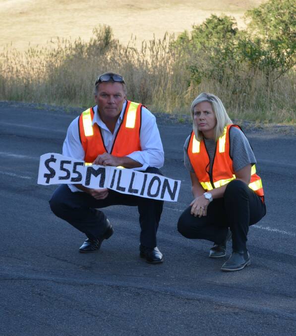 Corangamite Shire councillor Simon Illingworth and mayor Jo Beard with the sign showing the money still needed from the state government to fix the arterial road network.