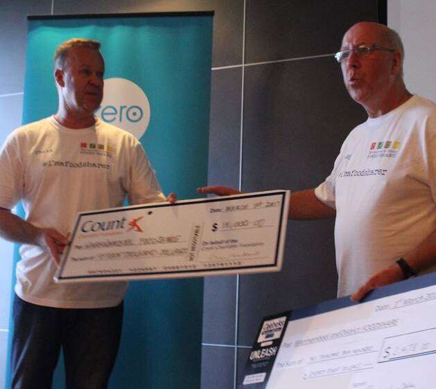 Food Share's Dedy Friebe receives a cheque from Chris Beks.