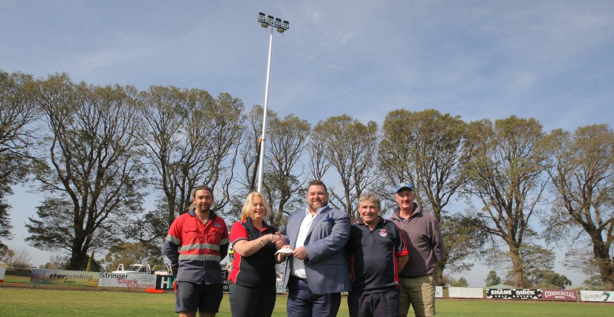 Let there be light: Electrician Scott Narik, recreation reserve representative Jane Irving, Mark McIlroy, from Raffertys Tavern, Terang Mortlake Football Netball Club president Jack Kenna and trustee Michael Heffernan in front of one of the new light towers.