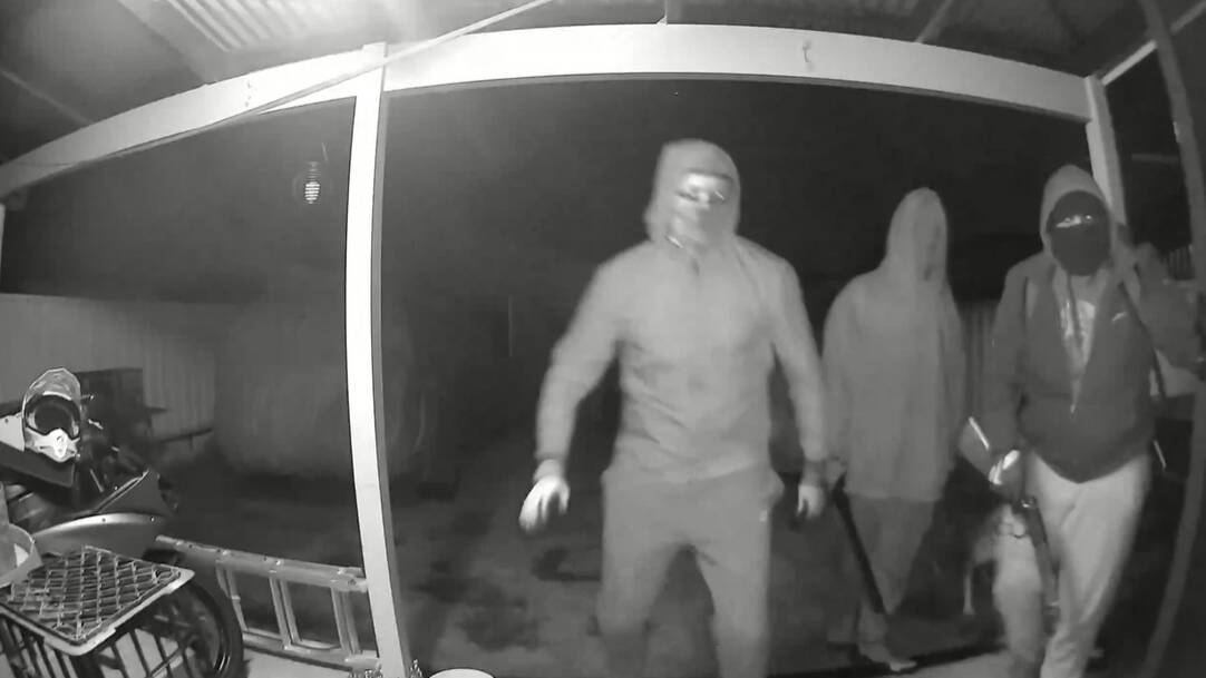 A still of a video which showed men armed with a machete and a shotgun attempt to break into a home. Picture by NSW Police. 