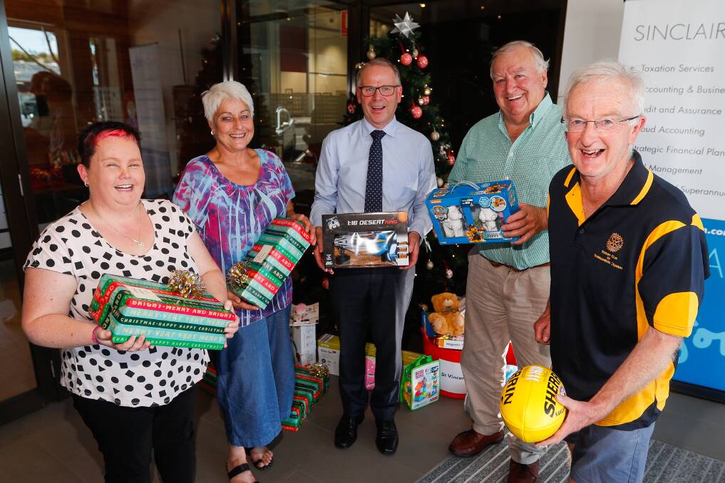 Giving to kids in need: Anna, Marion Noye, John Bouwman, Chris Nolan and Lew Officer with gifts next to the tree at Sinclair Wilson. Picture: Morgan Hancock