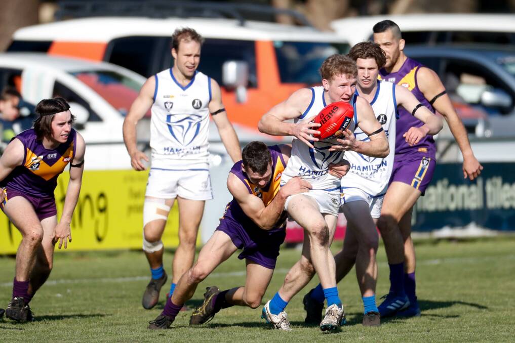 TRYTING TO BREAK AWAY: Hamilton Kangaroos' Bailey Mason is tackled by a Port Fairy opponent during a game at Gardens Oval earlier this year. Picture: Chris Doheny