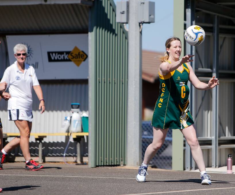 Officiating: An umpire watches as Old Collegians' Rachel Alderson gets a pass away in the Warrnambool and District league. Picture: Anthony Brady