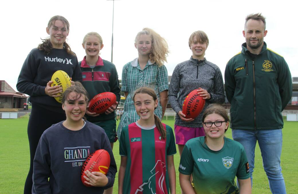 Welcoming new players: Old Collegians' under 18 girls team at football training on Thursday evening with coach Xavier Couch. Picture: Brian Allen