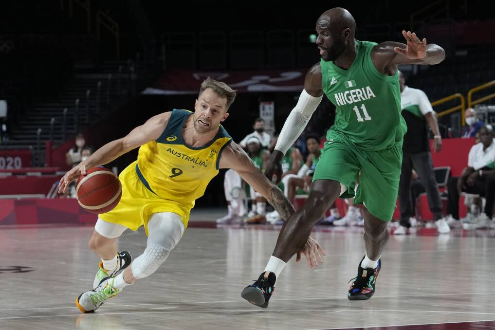 Milestone: Warrnambool export and Australian Boomer Nathan Sobey drives around Nigeria's Obi Emegano on Sunday night in Tokyo. Sobey played his first Olympic minutes. Picture: AP Photo/Eric Gay