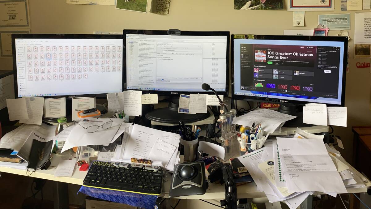 Colin Gray runs the operation from his desk where he has three computer screens set up to keep track of the finances, including for a number of community organisations.