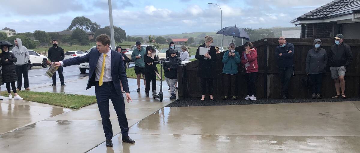 SELLING: Rain didn't hamper auctioneer Fergus Torpy selling a four bedroom house at an auction in Warrnambool on Saturday.