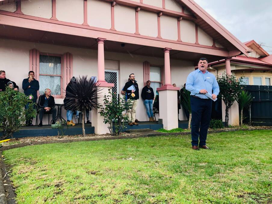SOLD: Auctioneer Tim Wells sells the three bedroom Banyan Street house at auction on Saturday.
