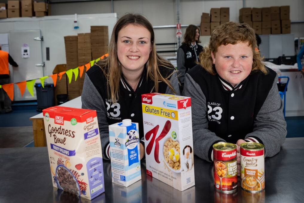 Brauer College students Keira Longmore and Liam Bell with some of the 483 kilograms of food the school community donated to Warrnambool and District Foodshare. Picture by Anthony Brady