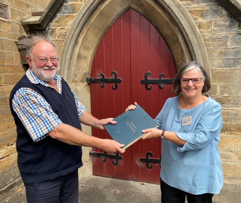 Rare: Western Victorian Association of Historical Societies president Michael Menzies presents Warrnambool and District Historical Society president Janet Macdonald with a scrap book with clippings about Edmund Vidler's role in the city in the early 1900s. Picture: Madeleine McNeil